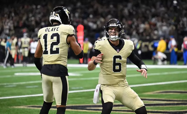 New Orleans Saints wide receiver Chris Olave, left, celebrates with quarterback Tyler Shough (6) after scoring a touchdown during the second half of an NFL football game against the New York Jets, Sunday, Dec. 21, 2025, in New Orleans. (AP Photo/Ella Hall)