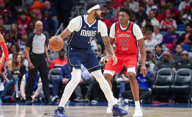 Dallas Mavericks forward Anthony Davis (3) tries to make a move against New Orleans Pelicans center Derik Queen (22) in the first half of an NBA basketball game Monday, Dec. 22, 2025, in New Orleans. (AP Photo/Peter Forest)