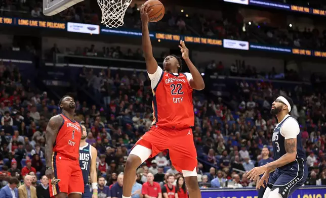 New Orleans Pelicans center Derik Queen (22) drives past Dallas Mavericks forward Anthony Davis (3) for a layup in the first half of an NBA basketball game Monday, Dec. 22, 2025, in New Orleans. (AP Photo/Peter Forest)