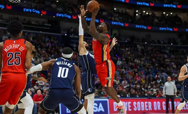 New Orleans Pelicans forward Zion Williamson (1) shoots a layup against Dallas Mavericks forward Daniel Gafford, left, in the first half of an NBA basketball game Monday, Dec. 22, 2025, in New Orleans. (AP Photo/Peter Forest)
