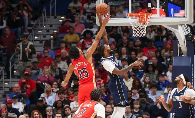 New Orleans Pelicans forward Trey Murphy III (25) and Dallas Mavericks forward Naji Marshall (13) both fight for the ball in the first half of an NBA basketball game Monday, Dec. 22, 2025, in New Orleans. (AP Photo/Peter Forest)