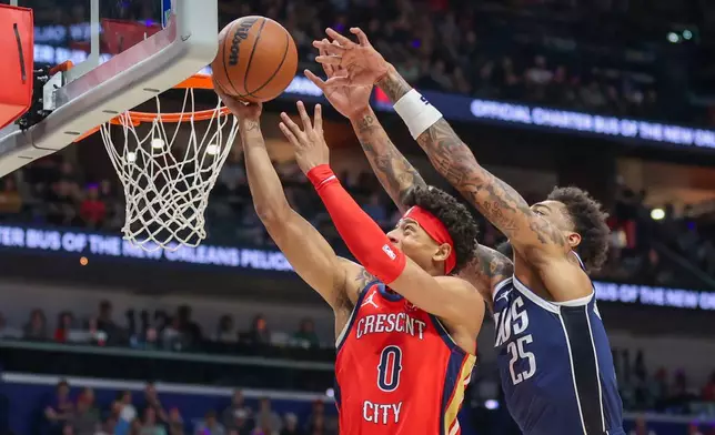 New Orleans Pelicans guard Jeremiah Fears (0) shoots a layup against Dallas Mavericks forward P.J. Washington (25) in the first half of an NBA basketball game Monday, Dec. 22, 2025, in New Orleans. (AP Photo/Peter Forest)