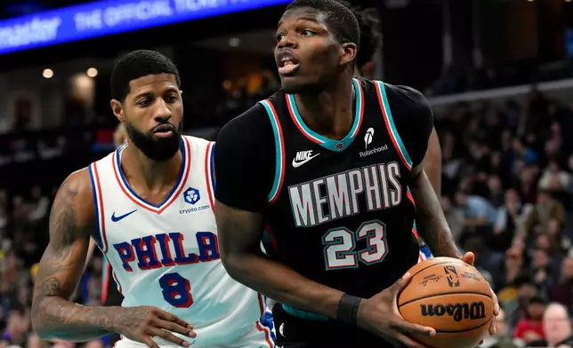 Memphis Grizzlies guard Cedric Coward (23) handles the ball ahead of Philadelphia 76ers forward Paul George (8) in the first half of an NBA basketball game Tuesday, Dec. 30, 2025, in Memphis, Tenn. (AP Photo/Brandon Dill)