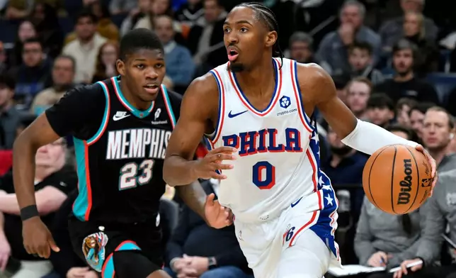 Philadelphia 76ers guard Tyrese Maxey (0) handles the ball ahead of Memphis Grizzlies guard Cedric Coward (23) in the second half of an NBA basketball game Tuesday, Dec. 30, 2025, in Memphis, Tenn. (AP Photo/Brandon Dill)