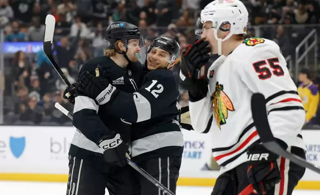 Los Angeles Kings left wing Warren Foegele (37) is greeted by Los Angeles Kings left wing Trevor Moore (12) after scoring during the second period of an NHL hockey game Saturday, Dec. 6, 2025, in Los Angeles. (AP Photo/Caroline Brehman)