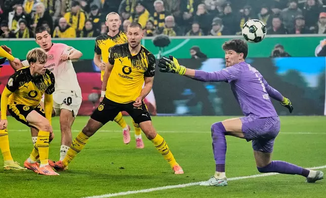 Leverkusen's Ibrahim Maza, second from left, scores the opening goal during the German Soccer Cup round of sixteen soccer match between Borussia Dortmund and Bayer 04 Leverkusen in Dortmund, Germany, Tuesday, Dec. 2, 2025. (AP Photo/Martin Meissner)