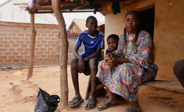 Precious Njikonye, right, the mother of a student at St. Mary's Catholic School, who was abducted by gunmen and later released, sits outside her house in Papiri, Nigeria, Wednesday, Dec. 10, 2025. (AP Photo/Afolabi Sotunde)
