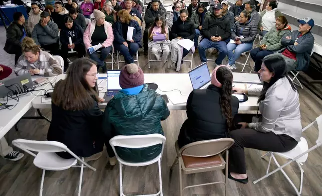 Tyson Foods employees wait for help at an informational meeting held by the Nebraska Department of Labor in Lexington, Neb., Wednesday, Dec. 3, 2025. (AP Photo/Thomas Peipert)