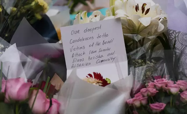 A condolence note left by a community member and attached to a flower at a tribute for shooting victims outside the Bondi Pavilion at Sydney's Bondi Beach, Monday, Dec. 15, 2025, a day after a shooting. (AP Photo/Mark Baker)