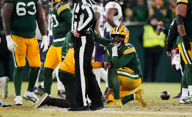 Green Bay Packers quarterback Malik Willis (2) reacts after an apparent injury during the second half of an NFL football game against the Baltimore Ravens, Saturday, Dec. 27, 2025, in Green Bay, Wis. (AP Photo/Morry Gash)