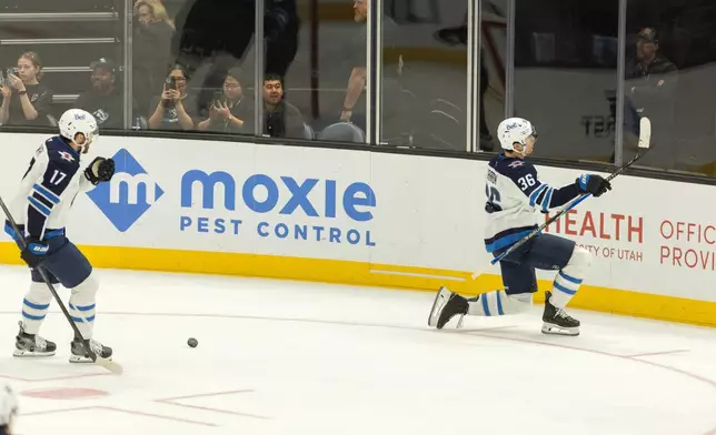 Winnipeg Jets center Morgan Barron (36) and Winnipeg Jets center Adam Lowry (17) celebrate the goal against the Utah Mammoth during the third period of an NHL hockey game, Sunday, Dec. 21, 2025, in Salt Lake City. (AP Photo/Melissa Majchrzak)