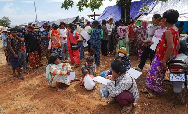 Evacuees wait for registration as they take refuge at Chonkal in Oddar Meanchey province, Cambodia Thursday, Dec. 11, 2025, after fleeing from home following a fighting between Thailand and Cambodia over territorial claims. (AP Photo/Heng Sinith)