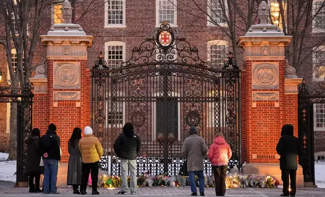 Visitors pause at a makeshift memorial for the victims of Saturday's shooting, at the Van Wickle Gate at Brown University, Monday, Dec. 15, 2025, in Providence, R.I.(AP Photo/Robert F. Bukaty)