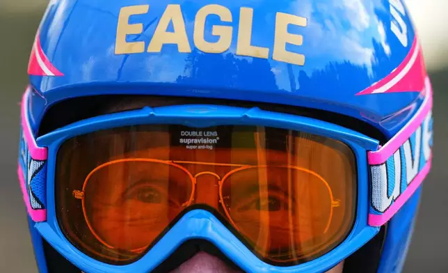 British former ski jumper Michael Edwards, known as Eddie the Eagle, wears a replica of his 1988 helmet with the original glasses, during an interview at the Ski and Snowboard Center, in Gloucester, England, Wednesday, Nov. 19, 2025. (AP Photo/Frank Augstein)