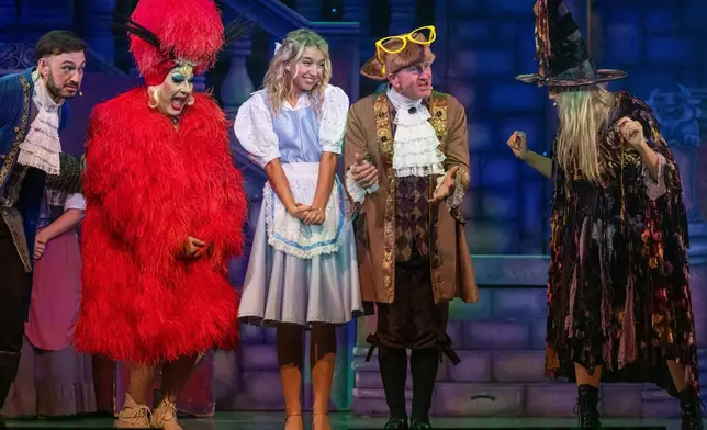 Michael Edwards, better known as Eddie the Eagle, center right, plays Professor Crackpot as he performs with fellow actors in the pantomime "Beauty and the Beast" at Watersmeet Theatre, in Rickmansworth, England, Dec. 5, 2025. (AP Photo/Thomas Krych)