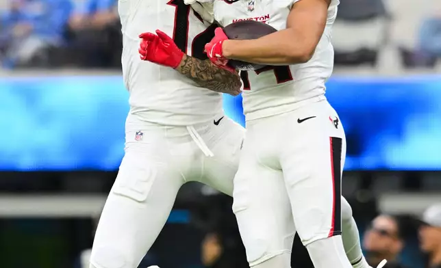 Houston Texans wide receiver Jaylin Noel, right, celebrates his touchdown with wide receiver Nico Collins during the first half of an NFL football game against the Los Angeles Chargers Saturday, Dec. 27, 2025, in Inglewood, Calif. (AP Photo/Wally Skalij)