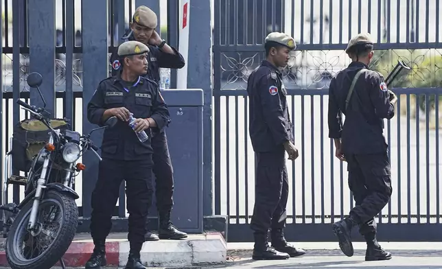 Cambodian police officers stand guard as they wait for 18 soldiers released after being captured and held by the Thai army, at former Phnom Penh International Airport in Phnom Penh, Cambodia, Wednesday, Dec. 31, 2025. (AP Photo/Heng Sinith)