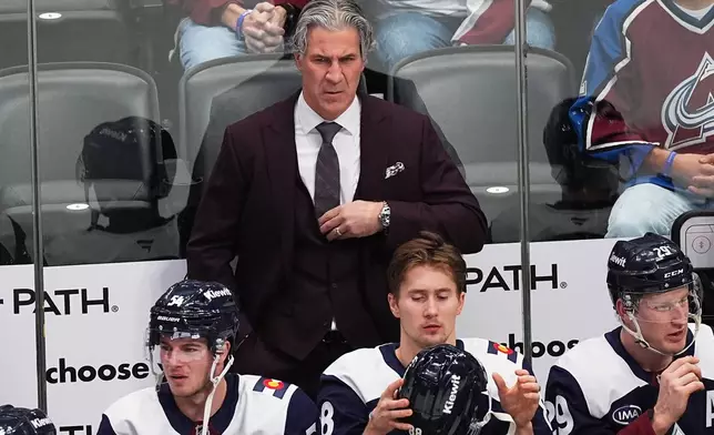 Colorado Avalanche head coach Jared Bednar, top, looks on from the team box in the first period of an NHL hockey game against the Winnipeg Jets, Friday, Dec. 19, 2025, in Denver. (AP Photo/David Zalubowski)