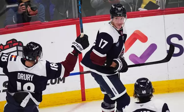 Colorado Avalanche center Parker Kelly (17) celebrates after scoring with center Jack Drury, left, and defenseman Samuel Girard, bottom right, in the third period of an NHL hockey game against the Winnipeg Jets, Friday, Dec. 19, 2025, in Denver. (AP Photo/David Zalubowski)