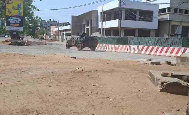 Soldiers ride in a military vehicle along a street amid an attempted coup in Cotonou Benin, Sunday Dec. 7, 2025. (AP Photo)
