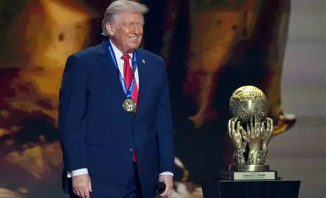 President Donald Trump smiles after being awarded the FIFA Peace Prize during the draw for the 2026 soccer World Cup at the Kennedy Center in Washington, Friday, Dec. 5, 2025. (AP Photo/Chris Carlson)