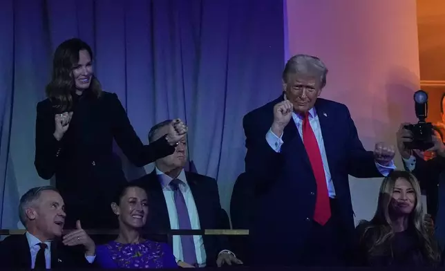 President Donald Trump dances to The Village People as Canadian Prime Minister Mark Carney, Mexican President Claudia Sheinbaum and First Lady Melania smile during the draw for the 2026 soccer World Cup at the Kennedy Center in Washington, Friday, Dec. 5, 2025. (AP Photo/Jacquelyn Martin)
