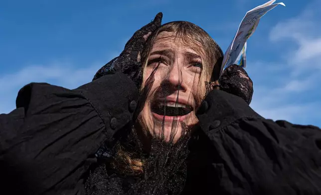 A woman wears a black mourning veil while attending a mock funeral for the penny, which was discontinued earlier this year, Saturday, Dec. 20, 2025, in front of the Lincoln Memorial in Washington. (AP Photo/Julia Demaree Nikhinson)