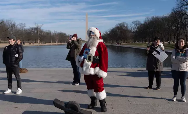 A person dressed as Santa attends a mock funeral for the penny, which was discontinued earlier this year, Saturday, Dec. 20, 2025, in front of the Lincoln Memorial in Washington. (AP Photo/Julia Demaree Nikhinson)
