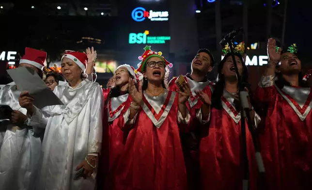 People sing Christmas carols in Jakarta, Indonesia, Tuesday, Dec. 23, 2025. (AP Photo/Dita Alangkara)