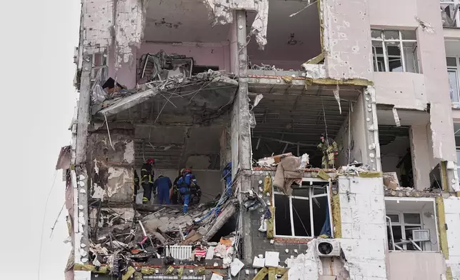 Rescuers work on the scene of a building damaged by a Russian attack in Kyiv, Ukraine, Saturday, Dec. 27, 2025. (AP Photo/Efrem Lukatsky)