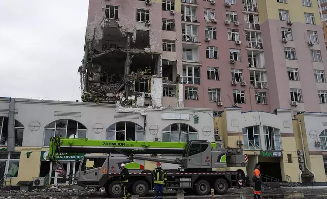 Rescuers work on the scene of a building damaged by a Russian attack in Kyiv, Ukraine, Saturday, Dec. 27, 2025. (AP Photo/Efrem Lukatsky)