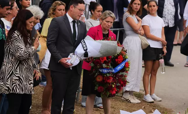 British Consul General Louise Cantillon, arrives at a memorial with flowers and a wreath during a tribute for victims of Sunday's shooting at the Bondi Pavilion at Bondi Beach on Tuesday, Dec. 16, 2025, in Sydney, Australia. (AP Photo/Mark Baker)