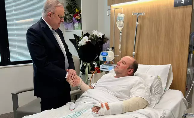 In this photo released by the Prime Minister office, Australian Prime Minister Anthony Albanese meets Ahmed al Ahmed at St George Hospital in Sydney, Tuesday, Dec. 16, 2025. (Australian Prime Minister Office via AP)