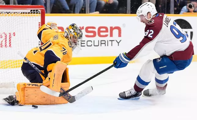 Nashville Predators goaltender Juuse Saros (74) blocks a penalty shot by Colorado Avalanche left wing Gabriel Landeskog (92) during overtime of an NHL hockey game Tuesday, Dec. 9, 2025, in Nashville, Tenn. (AP Photo/George Walker IV)