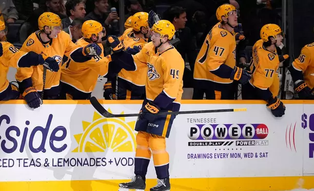 Nashville Predators left wing Reid Schaefer (49) celebrates his goal with teammates during the first period of an NHL hockey game against the Colorado Avalanche, Tuesday, Dec. 9, 2025, in Nashville, Tenn. (AP Photo/George Walker IV)
