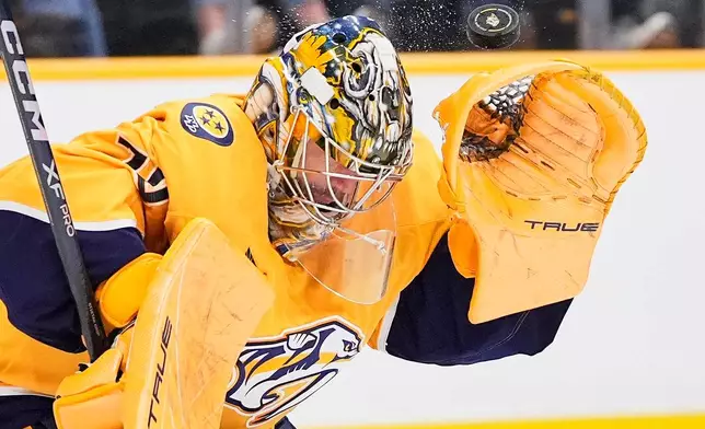 Nashville Predators goaltender Juuse Saros (74) deflects a shot on goal during the third period of an NHL hockey game against the Colorado Avalanche, Tuesday, Dec. 9, 2025, in Nashville, Tenn. (AP Photo/George Walker IV)