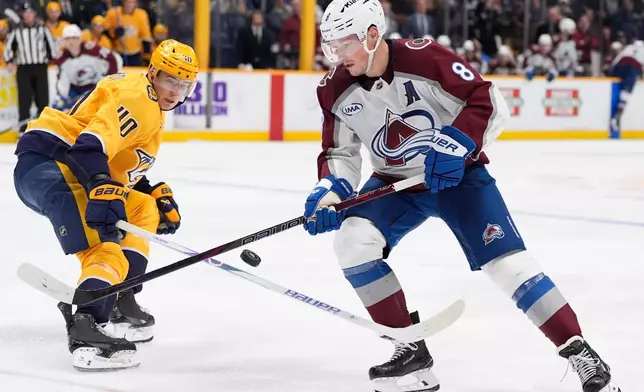 Colorado Avalanche defenseman Cale Makar (8) moves the puck past Nashville Predators center Fedor Svechkov (40) during the third period of an NHL hockey game Tuesday, Dec. 9, 2025, in Nashville, Tenn. (AP Photo/George Walker IV)