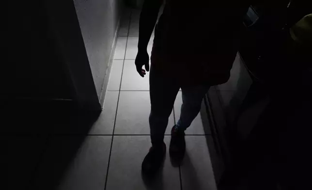 Guatemalan migrant Amavilia, 31, stands in the South Florida apartment where she lives with her two children and a roommate, after her partner Edgar was detained days after their son's birth and deported to Guatemala, Wednesday, Oct. 8, 2025. (AP Photo/Rebecca Blackwell)
