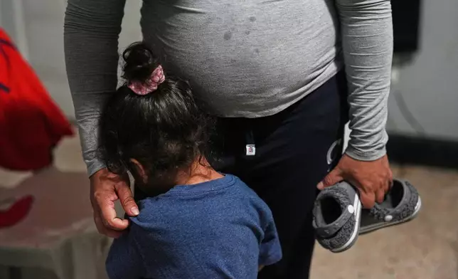 Pregnant asylum-seeker Yaoska, 32, comforts her two-year-old son who was not feeling well, inside the Miami-area motel room where she and her two children are living after her husband was deported to Nicaragua, Thursday, Nov. 13, 2025. (AP Photo/Rebecca Blackwell)