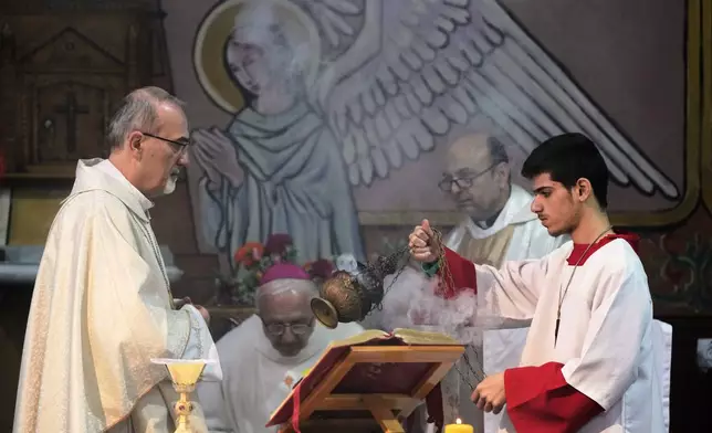Cardinal Pierbattista Pizzaballa, the Latin Patriarch of Jerusalem, left, leads a Christmas Eve Mass at the Holy Family Catholic Church in Gaza City, Sunday, Dec. 21, 2025. (AP Photo/Jehad Alshrafi)