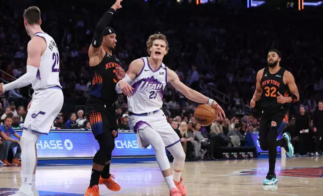 Utah Jazz forward Lauri Markkanen, center right, drives to the basket while New York Knicks guard Josh Hart, center left, defends during the first half of an NBA basketball game, Friday, Dec. 5, 2025, in New York. (AP Photo/Heather Khalifa)