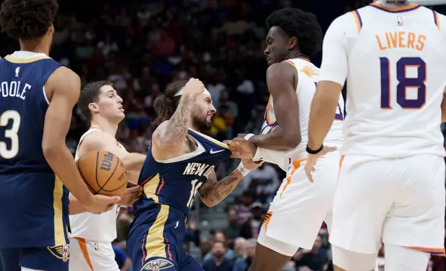 New Orleans Pelicans guard Jose Alvarado, center left, and Phoenix Suns center Mark Williams, center right, get into a scrum during the third quarter before both were ejected during an NBA basketball game in New Orleans, Saturday, Dec. 27, 2025. (AP Photo/Matthew Hinton)