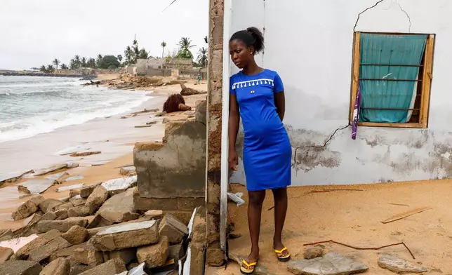 Afeli Bernice Adzo leans against the remains of her father's room as she looks at the ocean that destroyed her family home March 5, 2025, in Avegadzi, Ghana. (AP Photo/Misper Apawu, File)