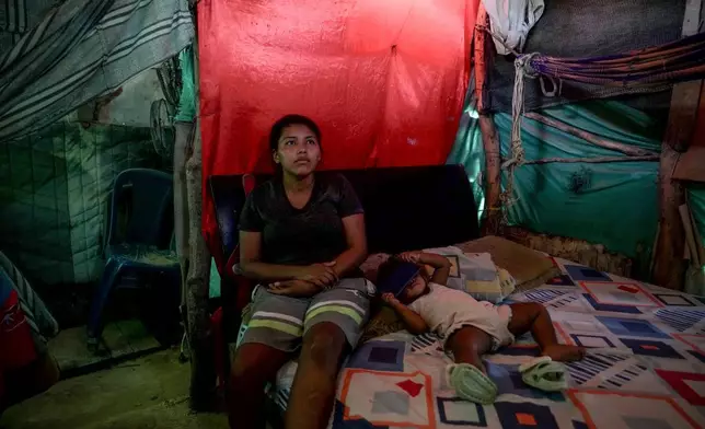 Luciane Mengual, 22, an Indigenous woman from the Wayuu community, poses with her baby at home Feb. 4, 2025, in the Villa del Sur neighborhood, on the outskirts of Riohacha, Colombia. (AP Photo/Ivan Valencia, File)