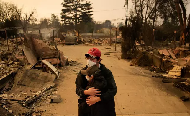 Ari Rivera, rear, and Anderson Hao hold each other in front of their destroyed home Jan. 9, 2025, in Altadena, Calif. (AP Photo/John Locher, File)