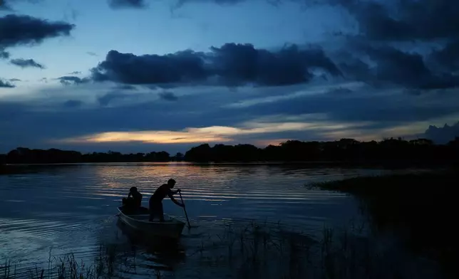 Members of the Mura Indigenous community maneuver a boat Feb. 17, 2025, in the Lago do Soares village in Autazes, Amazonas state, Brazil. (AP Photo/Edmar Barros, File)
