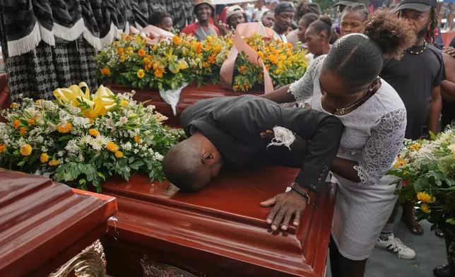 Relatives of Rosiclaire Lenchise mourn during a funeral of victims killed by a landslide triggered by Hurricane Melissa, Nov. 15, 2025, in Petit Goave, Haiti. (AP Photo/Odelyn Joseph, File)