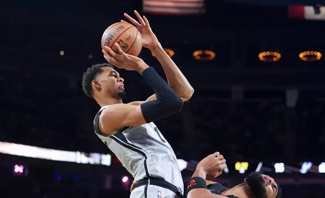 San Antonio Spurs forward Victor Wembanyama (1) shoots against New York Knicks center Karl-Anthony Towns (32) during the first half of the NBA Cup championship basketball game Tuesday, Dec. 16, 2025, in Las Vegas. (AP Photo/Ian Maule)