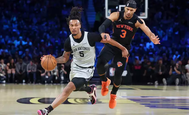 San Antonio Spurs guard Stephon Castle (5) drives against New York Knicks guard Josh Hart (3) during the first half of the NBA Cup championship basketball game Tuesday, Dec. 16, 2025, in Las Vegas. (AP Photo/Ian Maule)