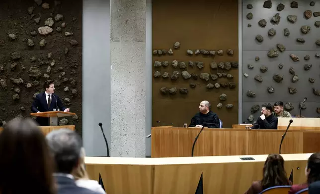 Ukraine's President Volodymyr Zelenskyy, right, attends a parliament session in The Hague, Netherlands, Tuesday, Dec. 16, 2025. (Robin van Lonkhuijsen/Pool Photo via AP)